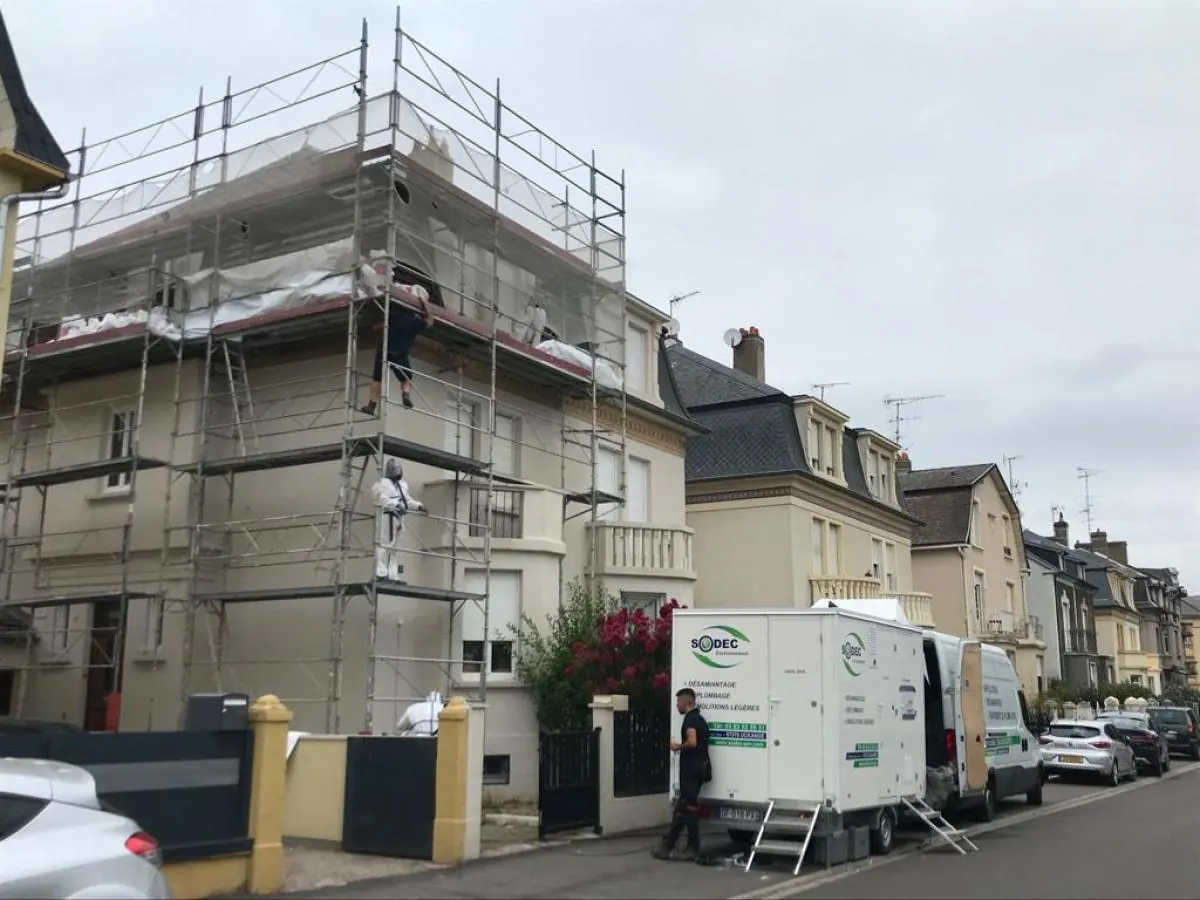 Échafaudage monté sur un immeuble, camion de chantier garé devant