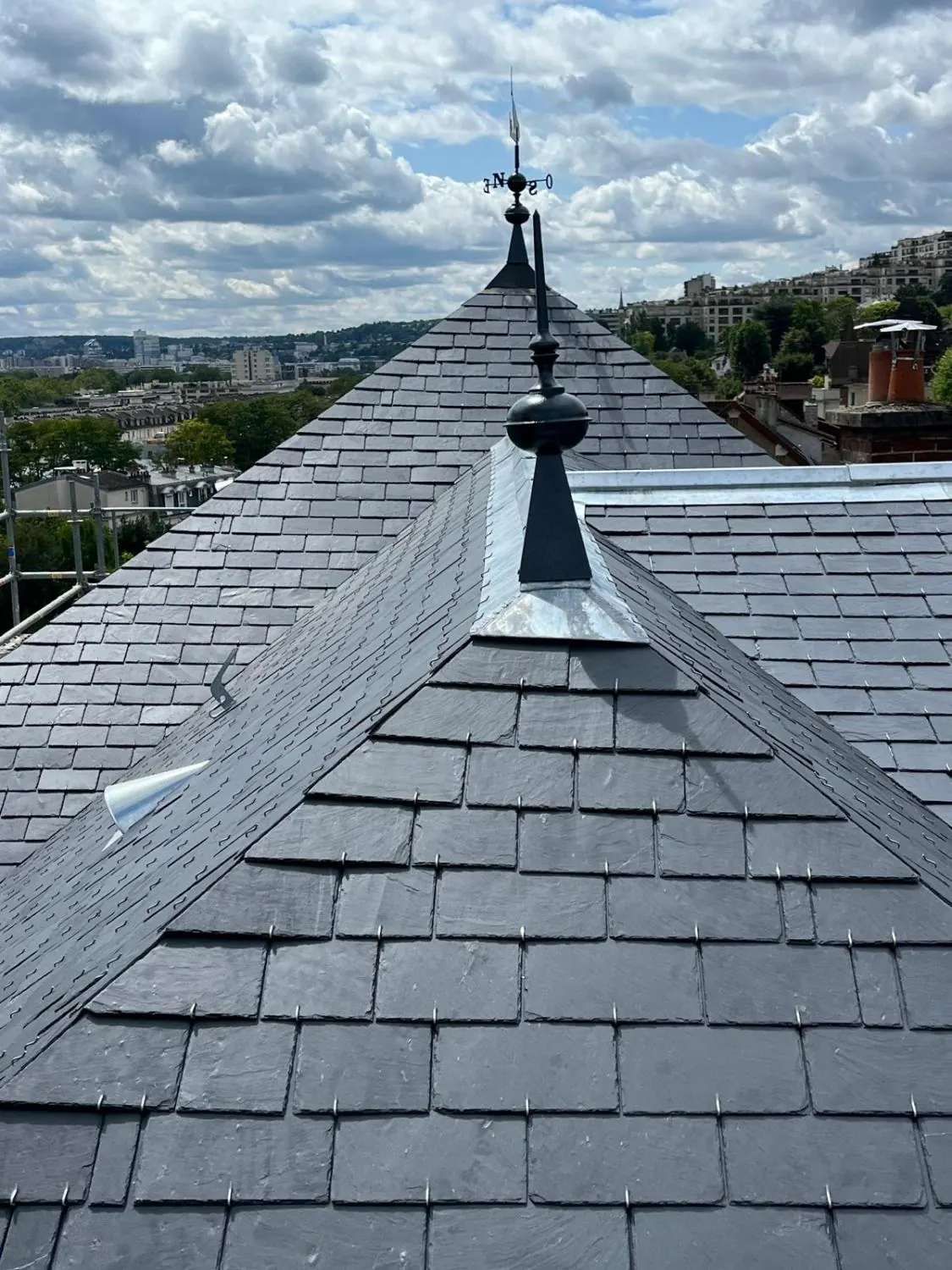 Épi de faîtage et arêtier en zinc sur une toiture en ardoise