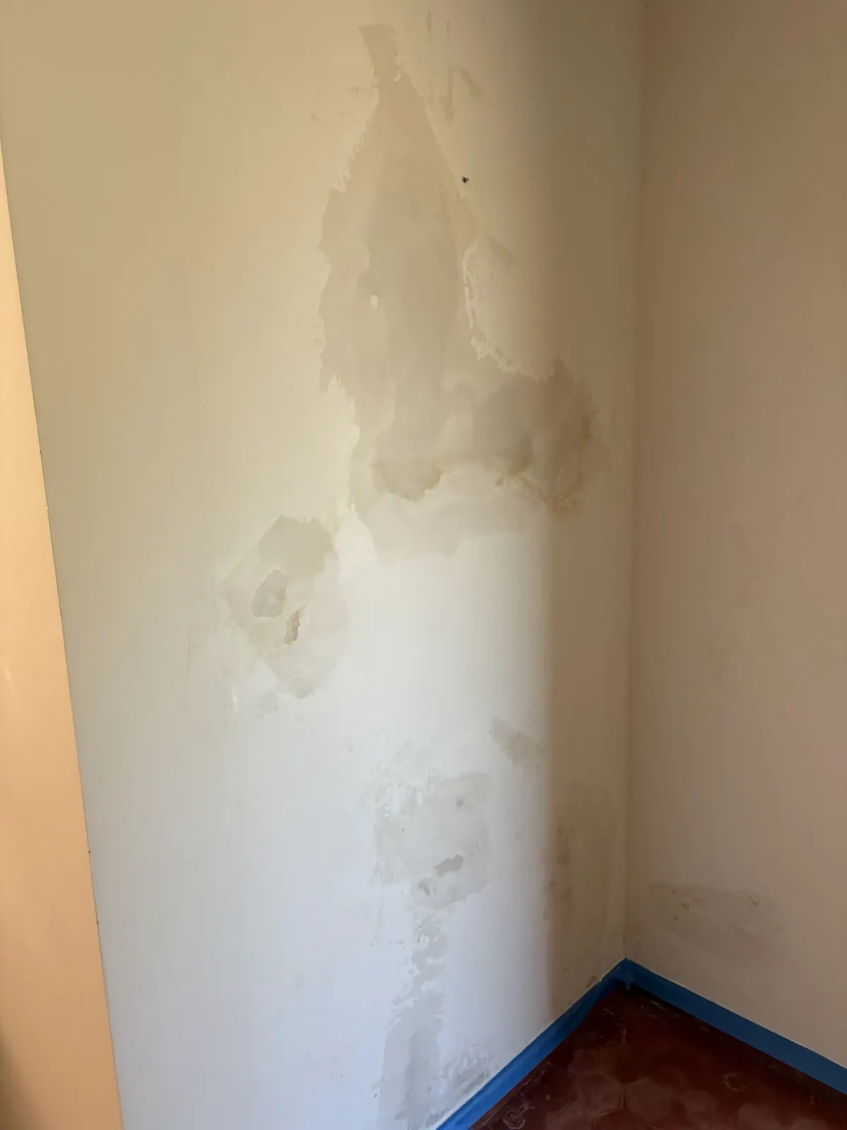 Traces d’infiltration d’eau sur le mur d’une pièce, peinture cloquée