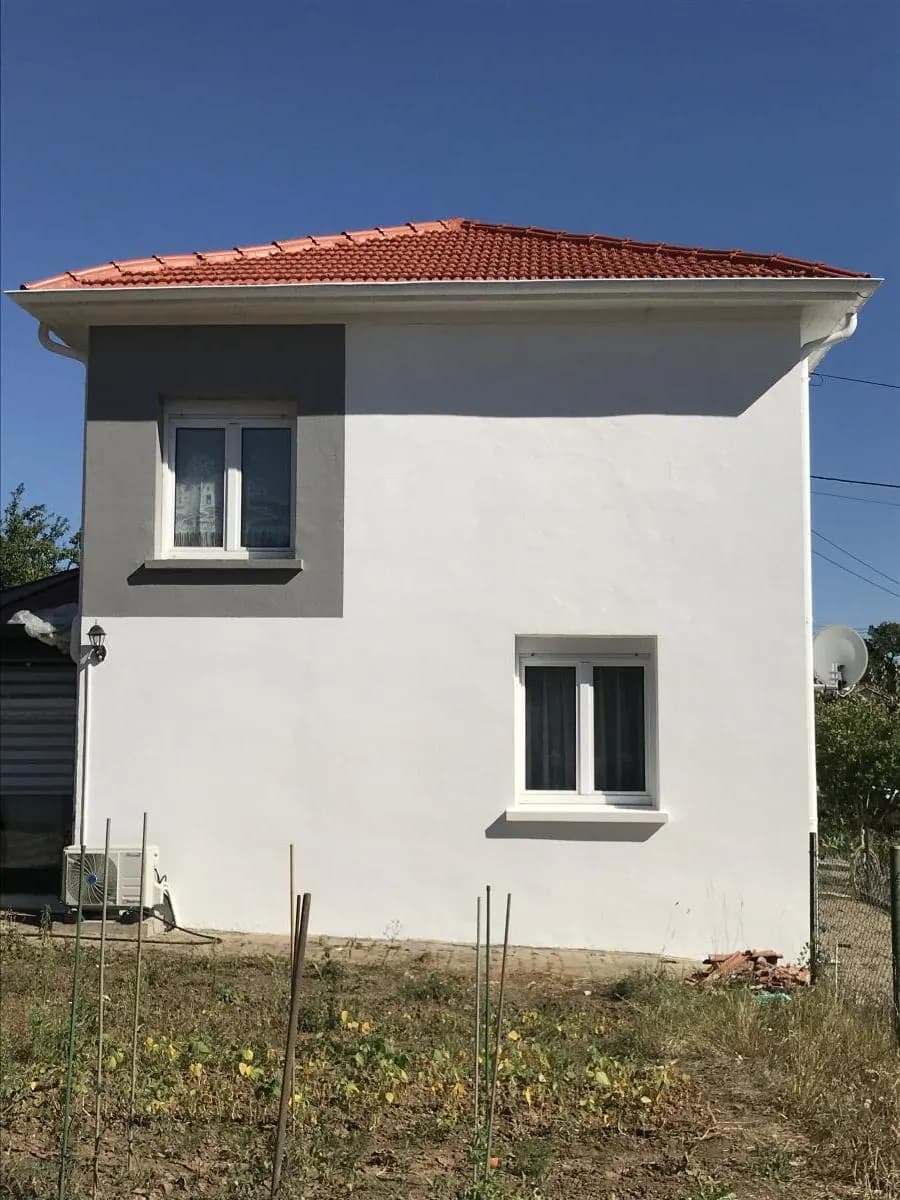 Maison blanche avec sa toiture en tuiles rouges et ses rives neuves