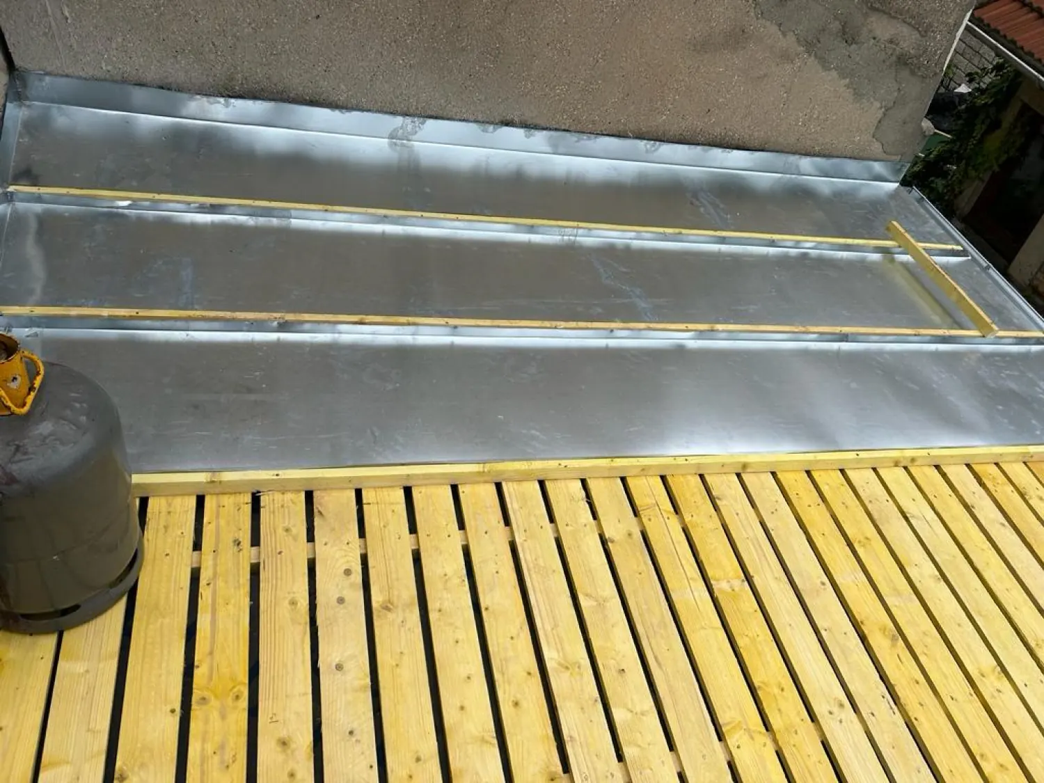 Feuilles de zinc posées sur un voligeage en bois neuf